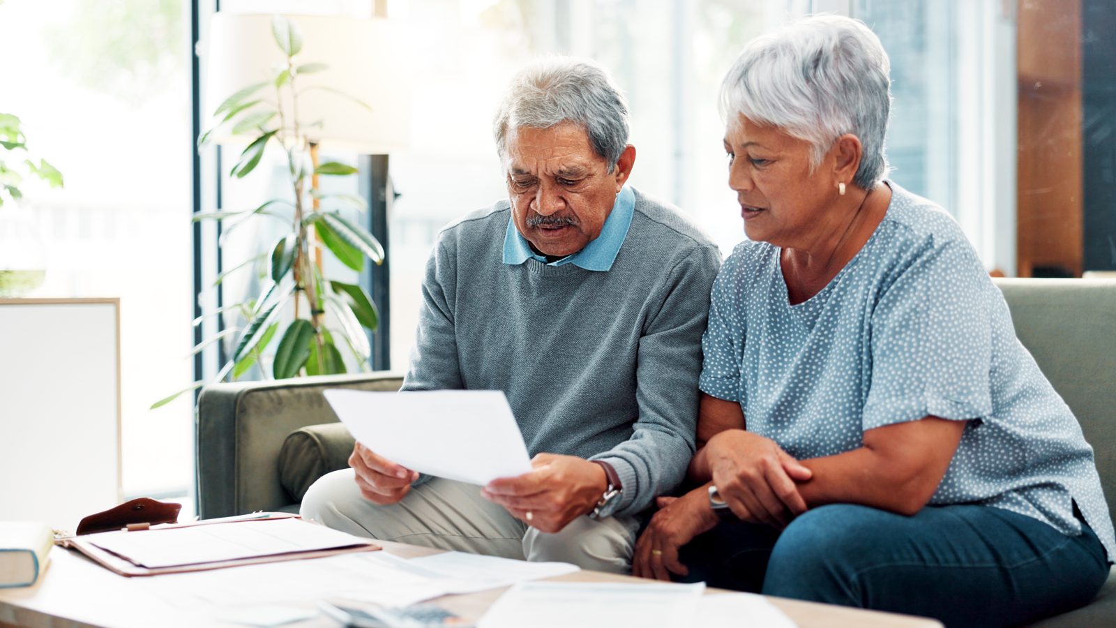 Older couple at home reviewing their alarm monitoring bill paperwork